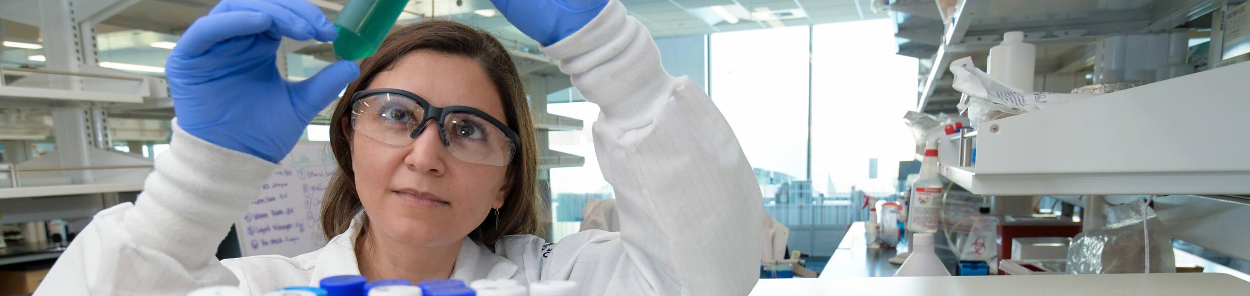 researcher looking at a test tube