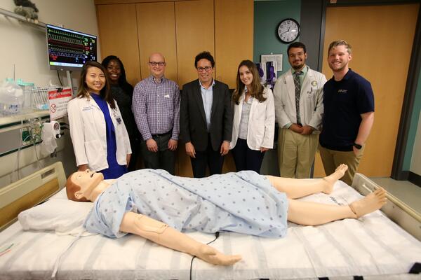 people standing next to sim lab bed